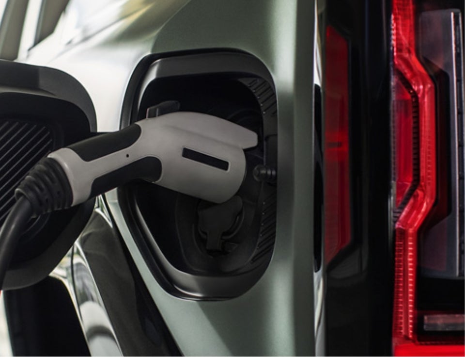 Close up of charging port with charger plugged in on a GMC Hummer EV SUV - Titus-Will GMC in Olympia WA